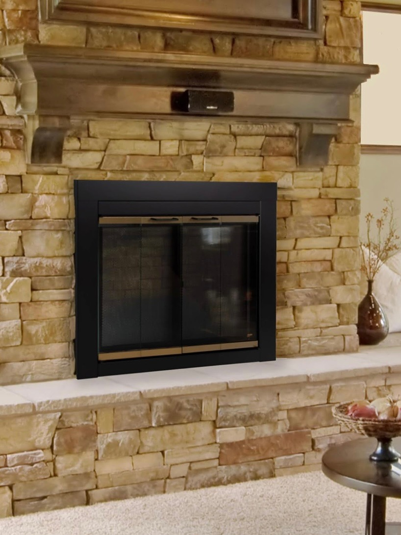 Fireplace with glass doors and stone surround inside residential home in Fremont CA